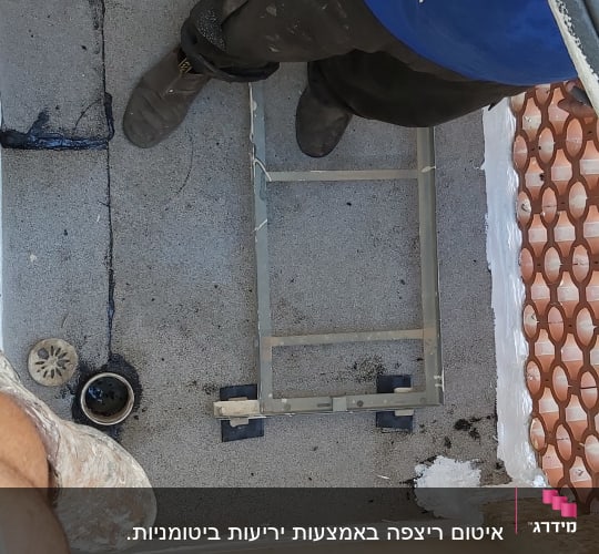 אדם עובד על איטום גג עם חומרים וכלים